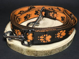 Palkar vodítko přepínací z popruhu pro psy 250 cm x 25 mm černo-oranžová s tlapkami